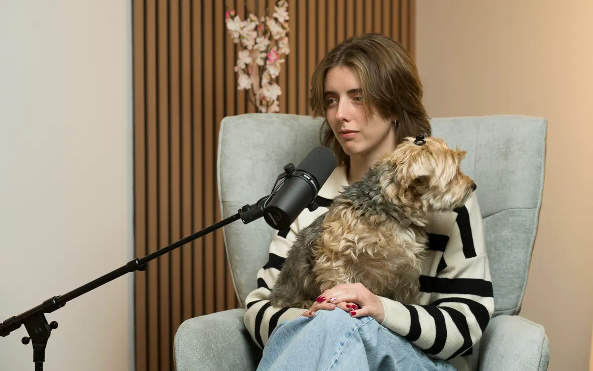 Invitada hablando al micrófono con su perro en brazos