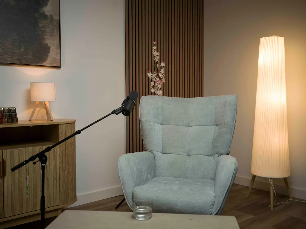 Sillón con micrófono y lámpara de pie en la sala blanca