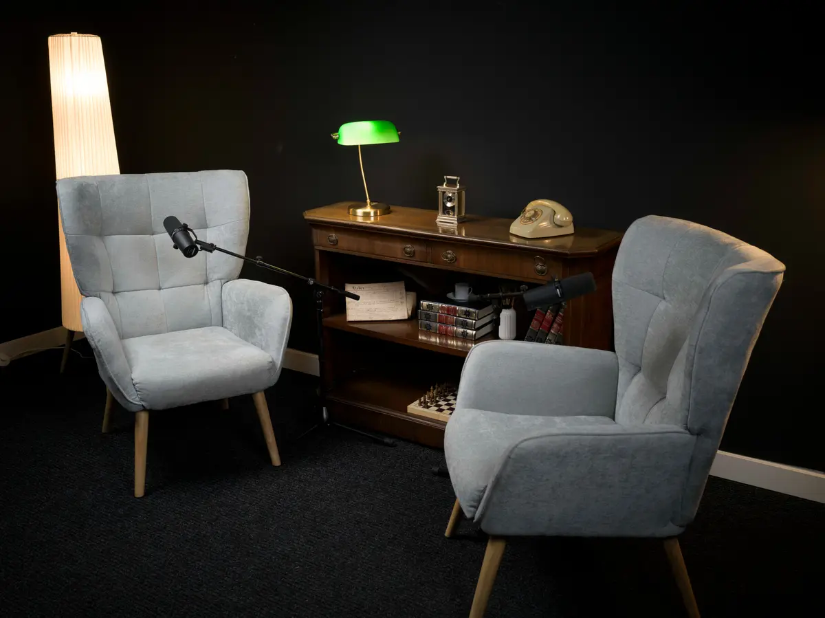 Sala negra con dos sillones, consola de madera y lámpara verde
